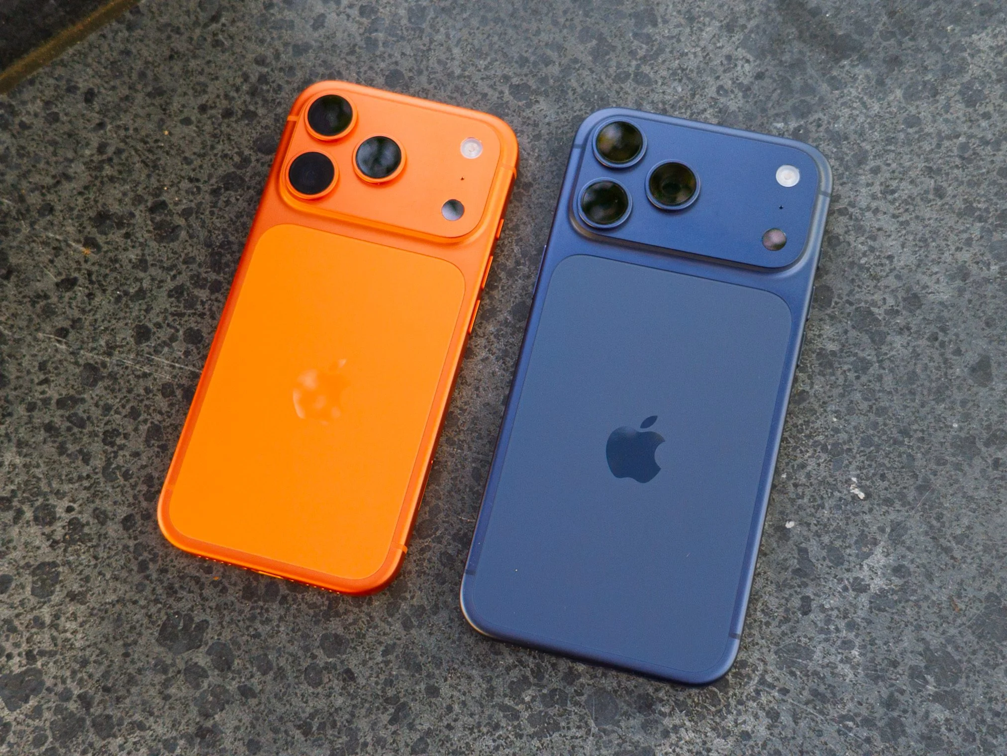Apple iPhone 17 Pro in Cosmic Orange next to the iPhone 17 Pro Max in Deep Blue