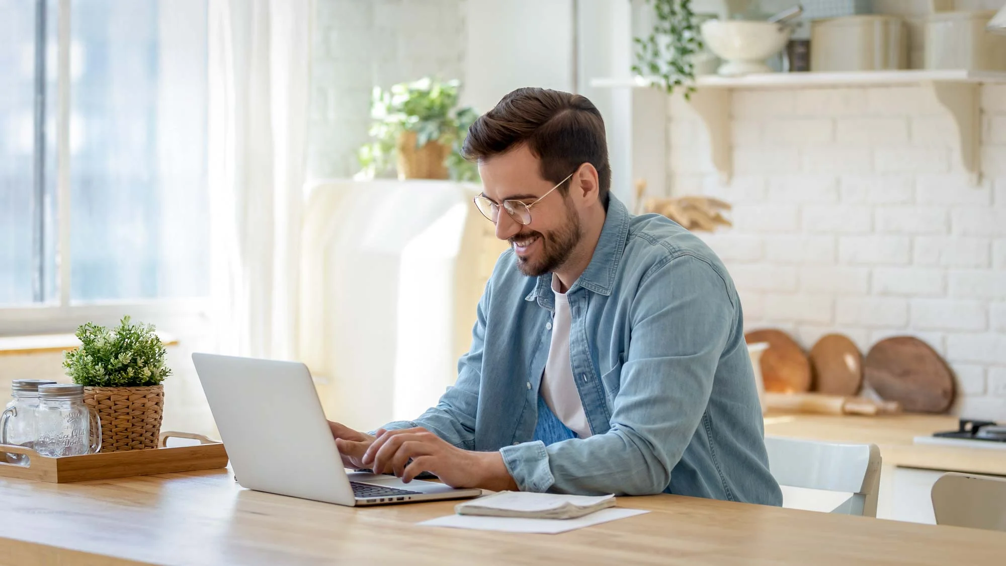 Man working from home kitchen on his laptop